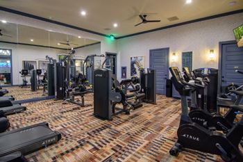 a gym with weights and cardio equipment in a building with glass walls at Elan Park, Columbus, OH 